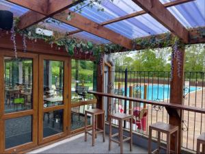 a screened in porch with stools and a pool at Eirlys in Caernarfon