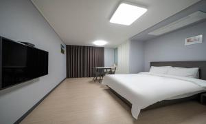 a hotel room with a bed and a flat screen tv at Myeongga Ubleth Hotel in Yeosu +37 photos