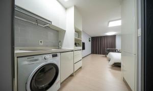 a kitchen with a washing machine in a room at Myeongga Ubleth Hotel in Yeosu