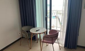 a room with a table and two chairs and a window at Myeongga Ubleth Hotel in Yeosu