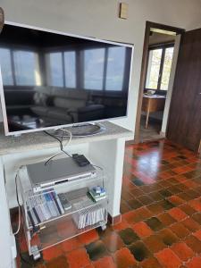 a living room with a counter with a large tv at La Finestra sul lago in Brissago