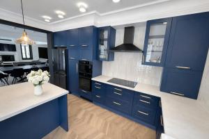 a kitchen with blue cabinets and a vase of flowers at Berek Kúria in Sonkád