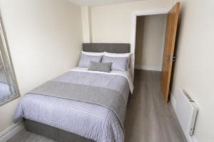 a bedroom with a large bed with a wooden door at Unit 5 Stunning Oceanview Apartment in Cobh