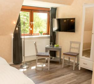 a bedroom with a desk and a bed and a window at Landgasthof Kasch - Hotel und Restaurant in Timmdorf
