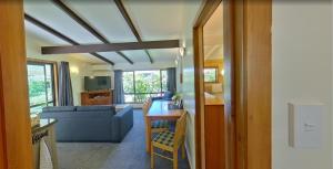 a living room with a blue couch and a table at Creel Lodge in Turangi