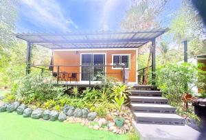 a home with a pergola and stairs to a house at Moon Jungle Bungalows in Ban Madua Wan