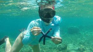 a person in the water with a mask on at El-Mindri Bungalow dan Resto in Gili Gede