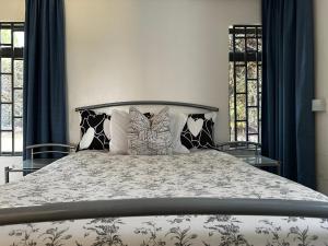 a bedroom with a large bed with blue curtains at Homely Cottage Near Lake Naivasha, Elwai Visitor Centre in Heni Village