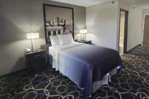 a hotel room with a large bed and two lamps at Super 8 by Wyndham Kansas City in Kansas City +48 photos
