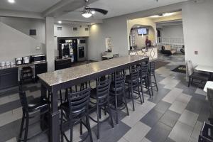 a large kitchen with a bar with stools at Super 8 by Wyndham Kansas City in Kansas City