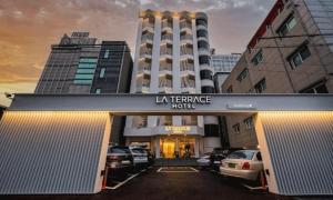 a hotel entrance with cars parked in a parking lot at Pohang Hotel La Terrace in Pohang