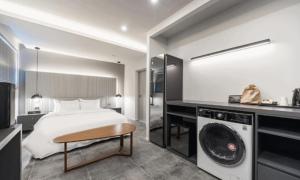 a bedroom with a bed and a washing machine at Pohang Hotel La Terrace in Pohang