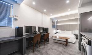 a hotel room with a bed and a desk and chairs at Pohang Hotel La Terrace in Pohang