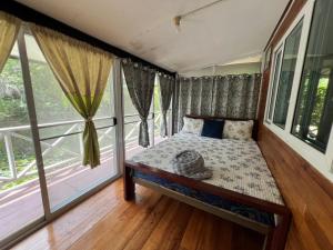a bedroom with a bed and a large window at Ariya Garden Home in Chumphon
