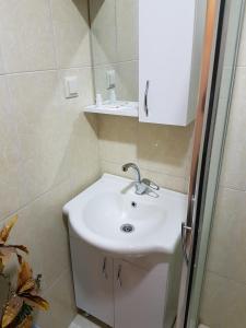 a bathroom with a white sink and a shower at Agora Park Hotel in İzmir