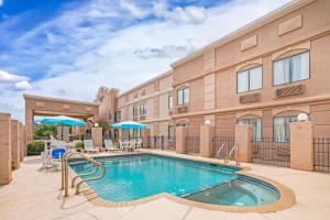 a pool at a hotel with chairs and umbrellas at Comfort Inn North Conroe in Conroe