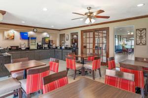 a dining room with tables and chairs and a ceiling fan at Comfort Inn North Conroe in Conroe