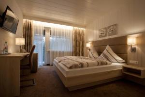 Dormitorio con cama, escritorio y TV en Landhaus Kramer, en Willingen