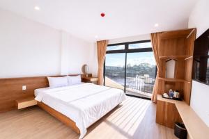 a bedroom with a bed and a large window at The SunHill Dalat in Ấp Ða Lợi