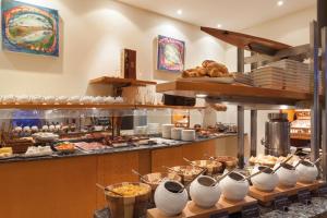 a kitchen with a bunch of food on display at Vienna House by Wyndham Baltic Stralsund in Stralsund