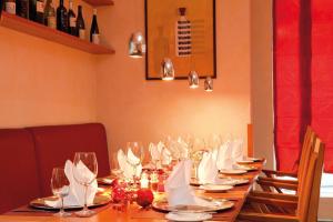 a long table with glasses and napkins on it at Vienna House by Wyndham Baltic Stralsund in Stralsund +55 photos