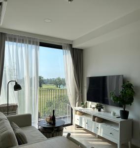 a living room with a couch and a television at Avrora Laguna Residences Sky Park in Ban Thalat Choeng Thale