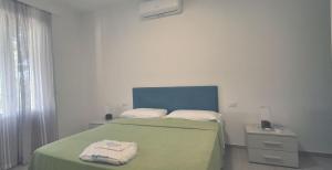 a bedroom with a bed with a green blanket at Villa Cedro in Capoliveri