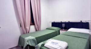 two green beds in a room with a window at Villa Cedro in Capoliveri