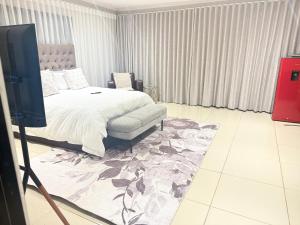 a bedroom with a bed and a tv in it at Latifahs Home in Rustenburg