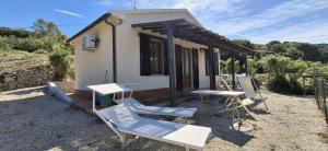a house with chairs and a table in front of it at Villa Oleandro in Capoliveri +9 photos