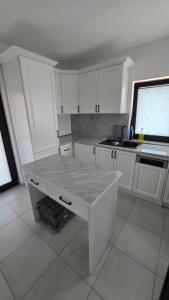 a kitchen with white cabinets and a marble counter top at House in Hudum - Botoșani in Hudum +76 photos