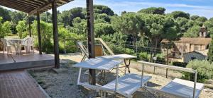 a patio with chairs and a table and a swing at Villa Oleandro in Capoliveri