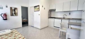 a kitchen with white cabinets and a sink and a table at Villa Oleandro in Capoliveri
