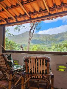 a porch with a chair and a view of the mountains at Viva o Capao - Casas in Palmeiras