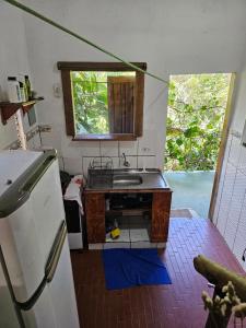 a small kitchen with a sink and a refrigerator at Viva o Capao - Casas in Palmeiras