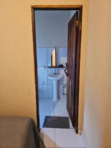 an open door to a bathroom with a sink at Viva o Capao - Casas in Palmeiras
