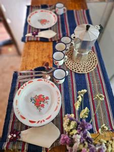 a table topped with plates and bowls on a table at Viva o Capao - Casas in Palmeiras +7 photos