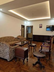 a living room with couches and tables and a flat screen tv at Winterfeel Bellmount by Neon Nest in Ooty