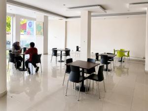 two people sitting at tables in a room at Marina Jampea Hotel in Makassar