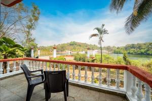 a balcony with two chairs and a view of a river at Mayem Lake View in Maem