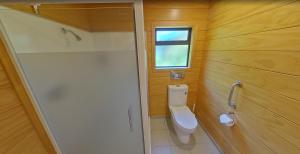 a small bathroom with a toilet and a shower at Creel Lodge in Turangi +59 photos