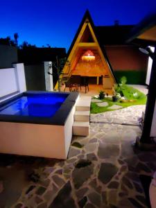 a house with a swimming pool in front of it at Garden Relax Bungalow "Deluxe Hotel Rooms, Pool, Parking" in Banja Luka