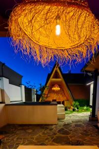 a building with a straw roof with a building at Garden Relax Bungalow "Deluxe Hotel Rooms, Pool, Parking" in Banja Luka