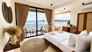 a bedroom with a bed and a view of the ocean at Meli Beach in Galle