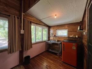 a kitchen with a red refrigerator and a sink at Ariya Garden Home in Chumphon