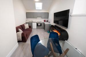 a living room with a glass table and blue chairs at Unit 4 Tranquil Harbourside Retreat- Central Location in Cobh