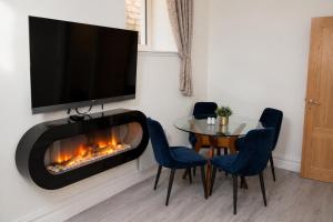a fireplace in a living room with a table and a tv at Unit 4 Tranquil Harbourside Retreat- Central Location in Cobh