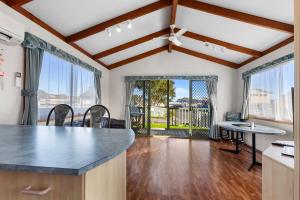 a kitchen and living room with a table and windows at Apollo Bay Holiday Park in Apollo Bay