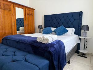 a bedroom with a blue and white bed with towels on it at Aloft Alvarado in Siguatepeque