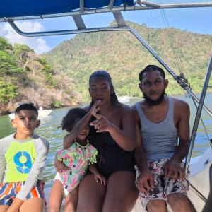 a man and two children sitting on a boat at Party on the islands in Carenage